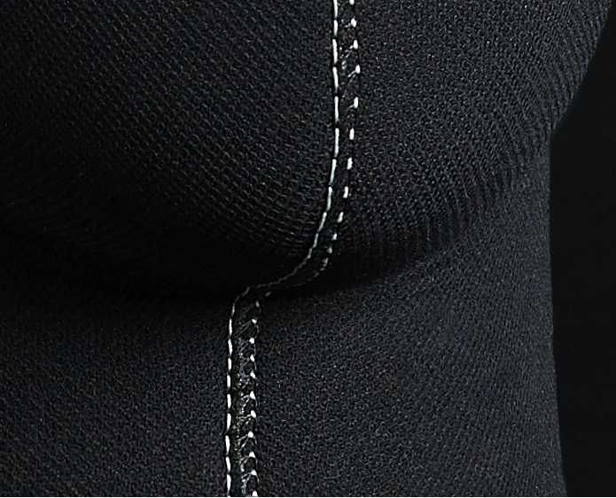 Couture cagoule detail with white stitching on black fabric